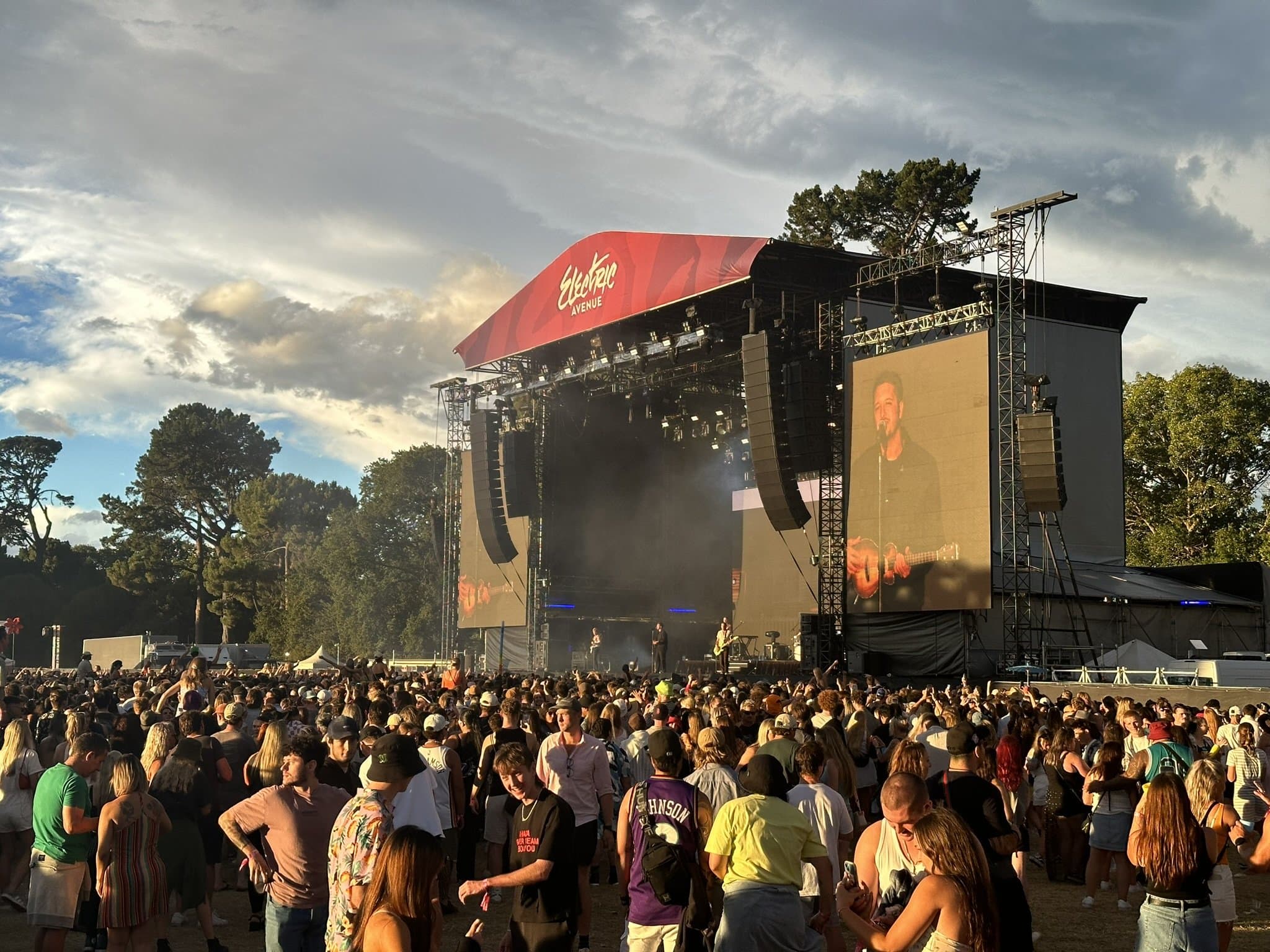 The crowd in front of the main stage at golden hour at the Electric Avenue music festival in Hagley Park, Christchurch